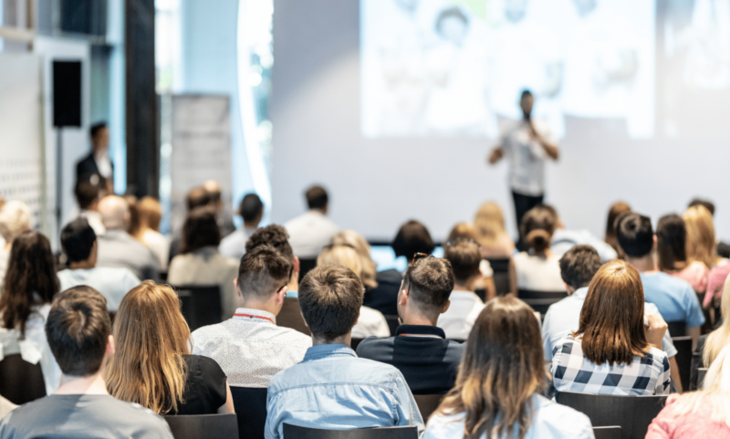 Attendees are listening to a speaker at a conference.