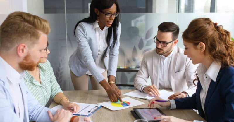Sales Managers and Sales Reps Gather Around a Table Brainstorming New Ideas and Collaborating