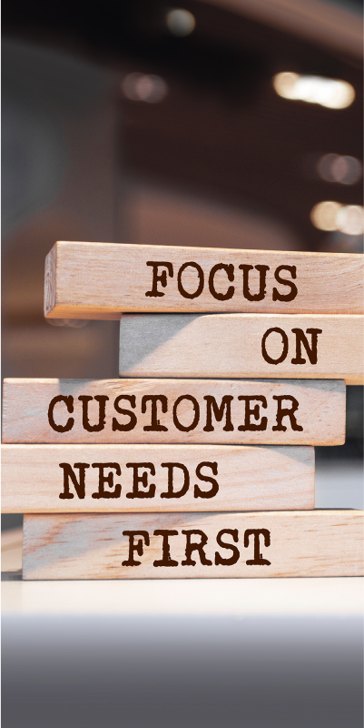 a Stack of Wooden Blocks with the Words "focus on Customer Needs First" Written on Them.