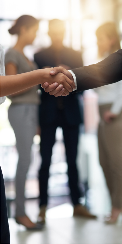 Business professionals shaking hands in a modern office, symbolizing successful collaboration and partnership.