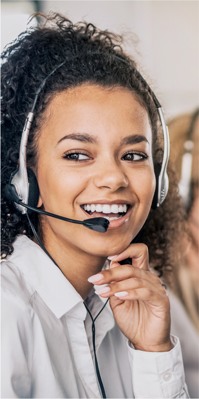 A woman in a call center wearing a headset, ready to assist customers with a friendly smile.