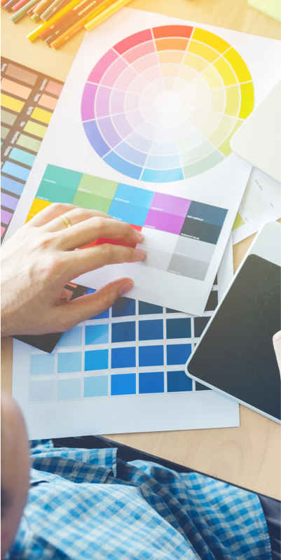 A person working on a computer with a color wheel, exploring various colors and their combinations.
