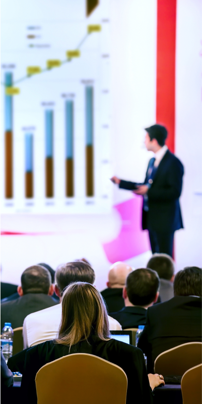 A person on a staging giving a presentation to an audience