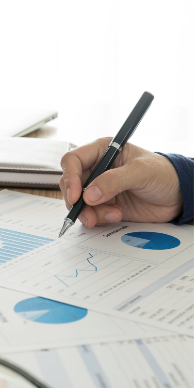 a Businessman's Hand Writes on Paper with a Pen and Calculator, Illustrating Financial Calculations.