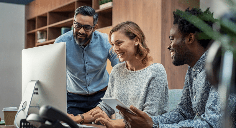 Team Collaborating at a Computer While Reviewing Data and Discussing Project Insights.